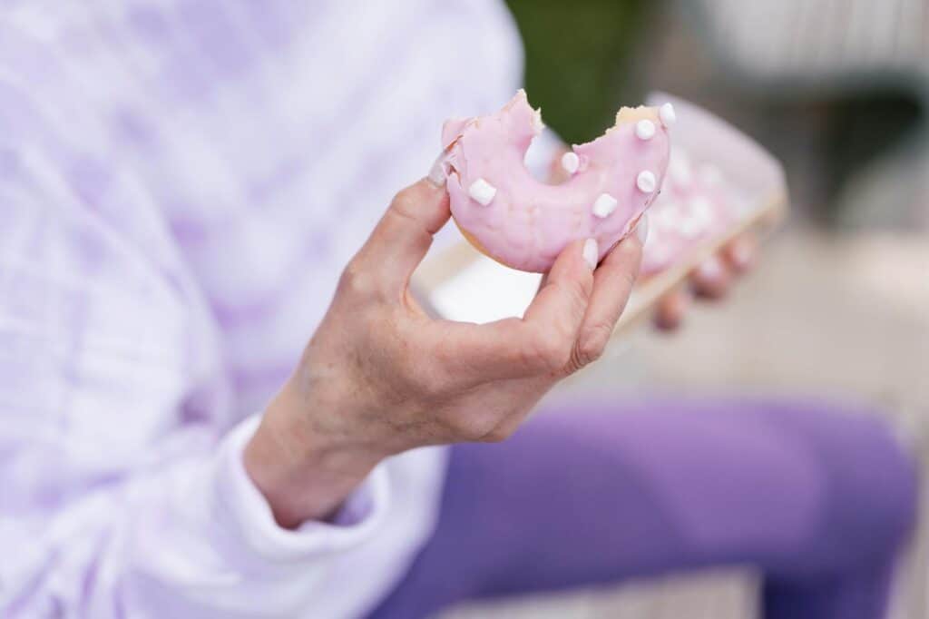 Woman taking a bite of a donut, representing indulging in sweet cravings