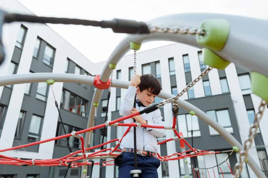 A Boy shaping the habit of Play on a Jungle Gym