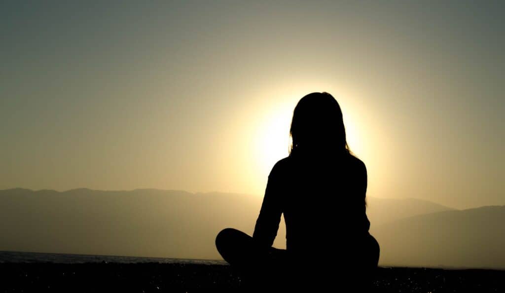 woman sitting on sand discovering mindfulness